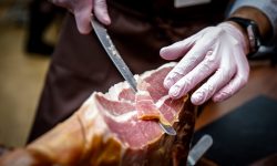 Hands of a men cut a slice of traditionally spanish jamon Hands of a men cut a slice of traditionally spanish jamon de bellota